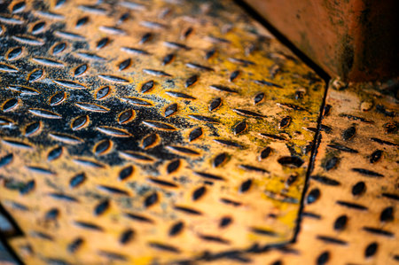 Authentic old style industrial background. Close-up of a dirty part of an old road roller. Orange colored metal.の写真素材