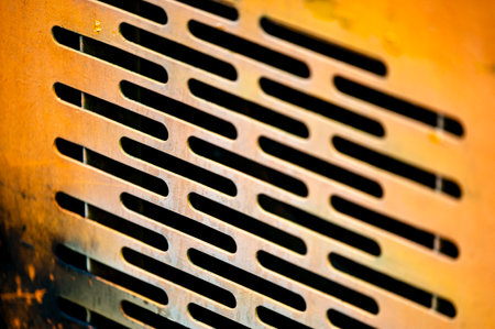 Authentic old style industrial background. Close-up of a dirty part of an old road roller. Orange colored metal.の写真素材