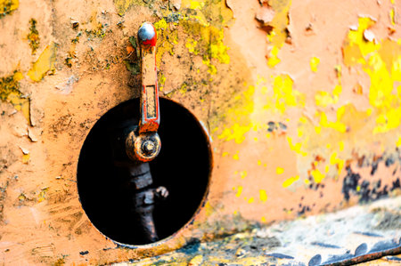 Authentic old style industrial background. Close-up of a dirty part of an old road roller. Orange colored metal.の写真素材