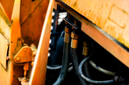 Authentic old style industrial background. Close-up of a dirty part of an old road roller. Orange colored metal.の写真素材