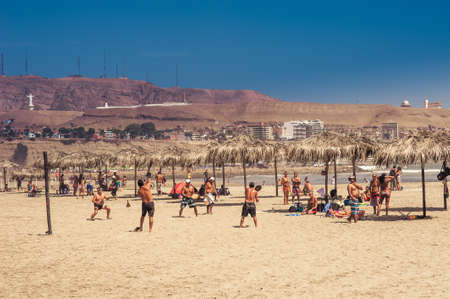 Peruvians play paddle ball (known locally as "frescobol") on Chorrillos beach with Solar hill mountain in the background at Lima, Peru- 1 May 2015のeditorial素材