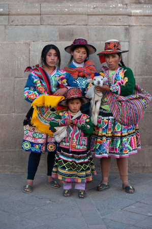 Peruvian family in traditional dress with llama posing for pictures on the Cusco, Peruのeditorial素材