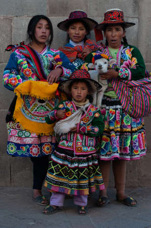 Peruvian family in traditional dress with llama posing for pictures on the Cusco, Peruのeditorial素材