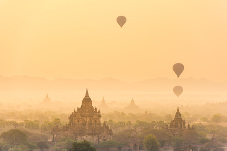 Hot air balloon over plain of Bagan in misty morning before sunrise, Myanmarの写真素材