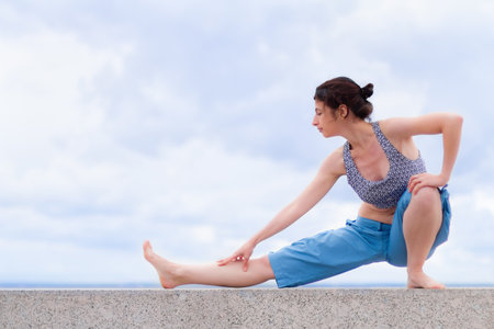 Young woman stretching outdoorsの写真素材