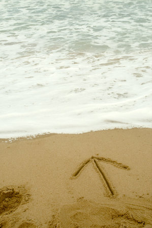 Arrow writen in the sandの写真素材