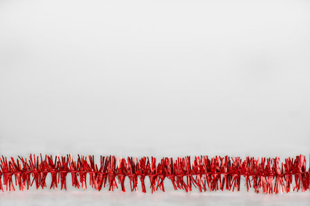 red tinsel on a white background with small highlights, christmas backgroundの写真素材