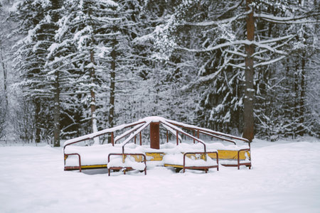 an abandoned carousel wrapped in snow is slowly aging and sad without childrens gamesの写真素材