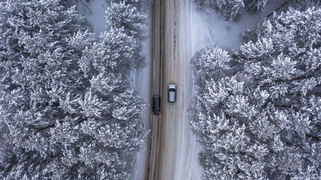 two cars met on a winter road in a fabulously beautiful forestの写真素材
