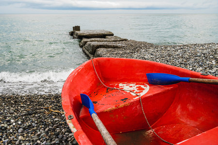 Red boat on the beach waiting to sail