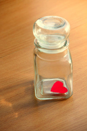 Heart trapped in a glass jar with closed lidの写真素材