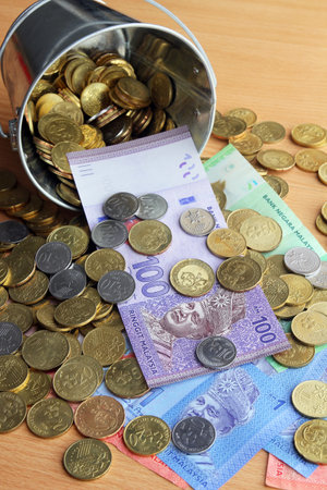 Bucket of spilled Malaysian Ringgit bank notes and coins