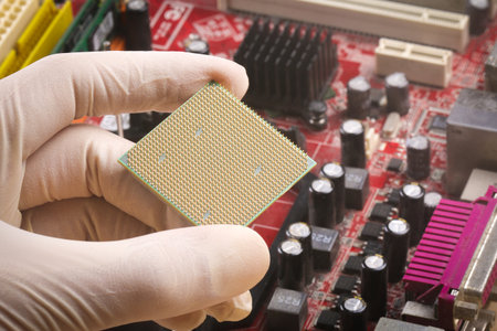 Gloved hand holding microprocessor chip