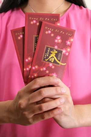 Holding Chinese New Year angpow money envelopesの写真素材