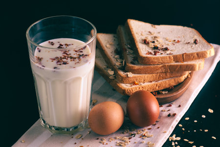 Two eggs, bread and a glass of milk on a linen tablecloth. Traditional breakfast.