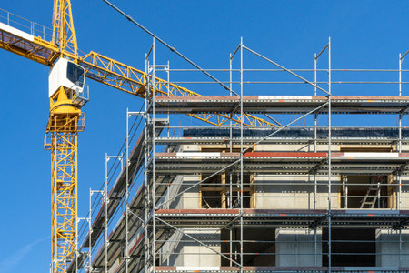Construction site with a scaffolding at the outside and crane in the backgroundの写真素材