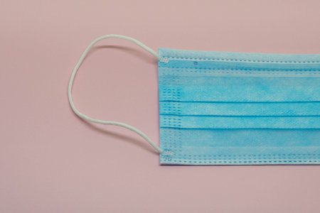 medical breathing mask for infection protection against eg SARS-CoV2 or covid-19 and other viruses, pink backgroundの写真素材