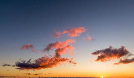 Cloudscape, Colored Clouds at Sunset near the Ocean on a Blue Skyの写真素材