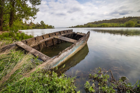 Old fishing boat on the shore of a lake in the countryside.の写真素材