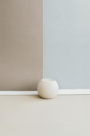 White wooden ball on the floor in front of a gray wall.の写真素材