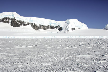 icecaps in the Antarctica with iceberg in the ocean swimming around and melting in the sea