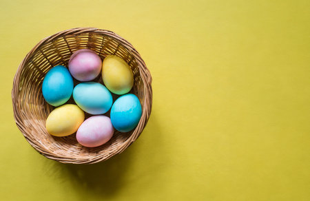 Colorful easter eggs in basket on yellow background. Happy Easter concept.の写真素材