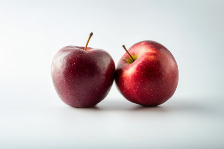 Two red apples on a white background, close-up, selective focus