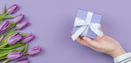 Gift box with white bow on purple background