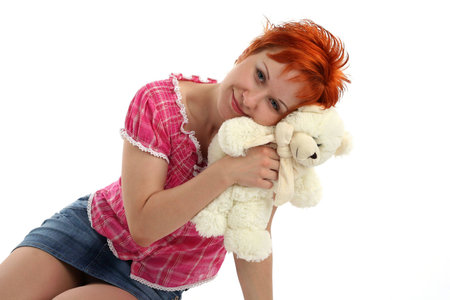 red haired woman with teddy bear isolated on white backgroundの写真素材