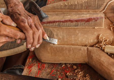 hands of the craftsman carve and tools of the wood carver