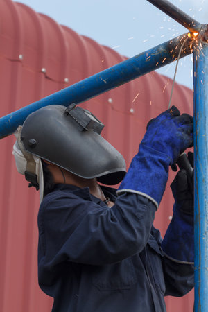 worker with protective mask welding metal