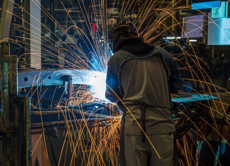 worker with protective mask welding metal