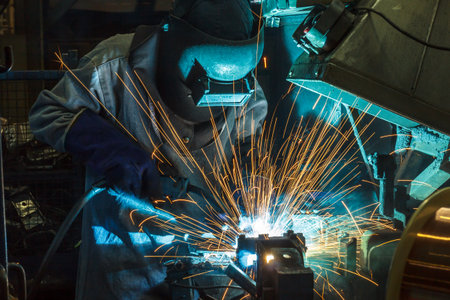 worker with protective mask welding metal