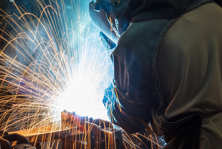 worker with protective mask welding metal