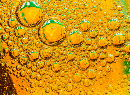 Oil drops on a water surface green abstraction with bubbles