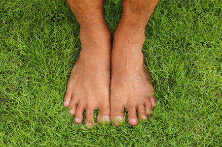 Foot lawn Bare man on the green grass