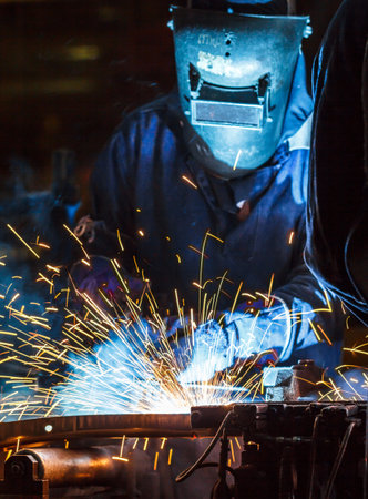 The movement of workers with protective mask welding metal.