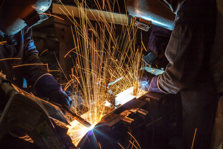 welder is welding steel structure with all safety equipment in factory