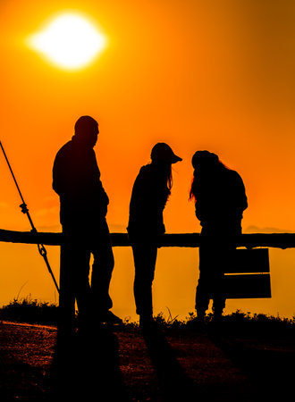 Shadow of people having fun in the sunrise in the morning.の写真素材