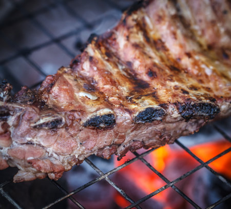 Grilled beef steaks over the coals on a barbecueの写真素材