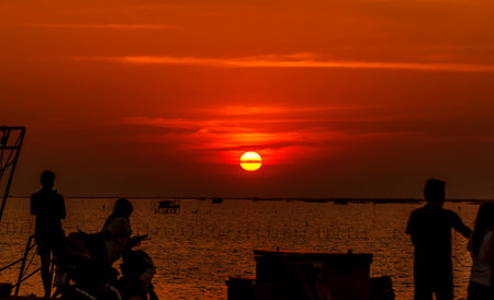 Sunset on the Beach, the sun reflecting off the clouds and sea orange.の写真素材