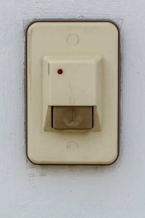 Close up doorbell in front of home on the isolated white wall