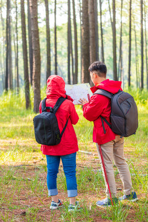 Men and women hiking with maps in the middle of natureの写真素材