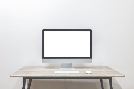 Blank computer monitor standing on a table in an open space office.の写真素材
