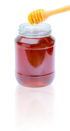 Composition with fresh honey dipper in a glass cup on white backgroundの写真素材