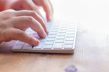 Stylish aluminum computer keyboard with beautiful woman's handの写真素材
