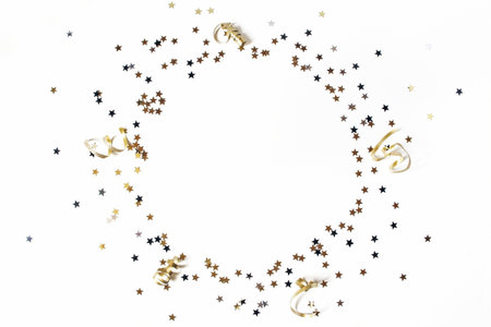 New Year festive composition. Circle made of black, silver and gold confetti stars and ribbons. Party decoration, celebration concept. Flat lay, top view. Empty space.の写真素材