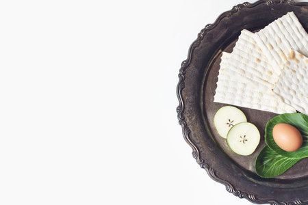 Seder dinner composition. Matzo bread, egg, apple fruit and chazeret lettuce vegetable on vintage...