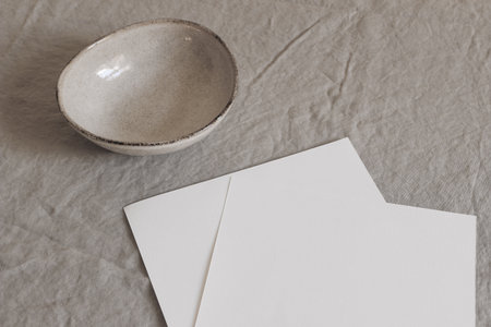 Closeup of empty paper sheets, pages mockups on beige table backgound. Office stationery concept....