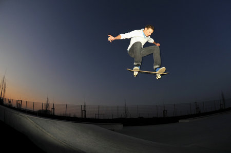 skateboarder flying high at the skate park in summertime の写真素材